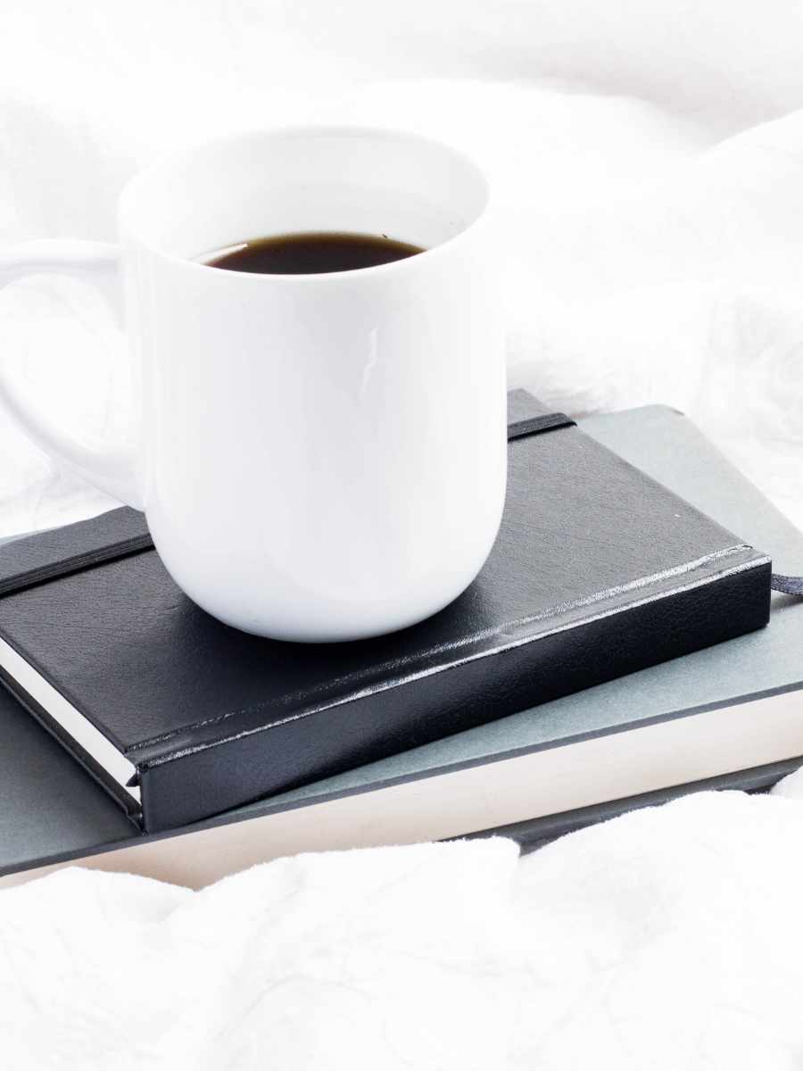 mug of coffee on top of two journals